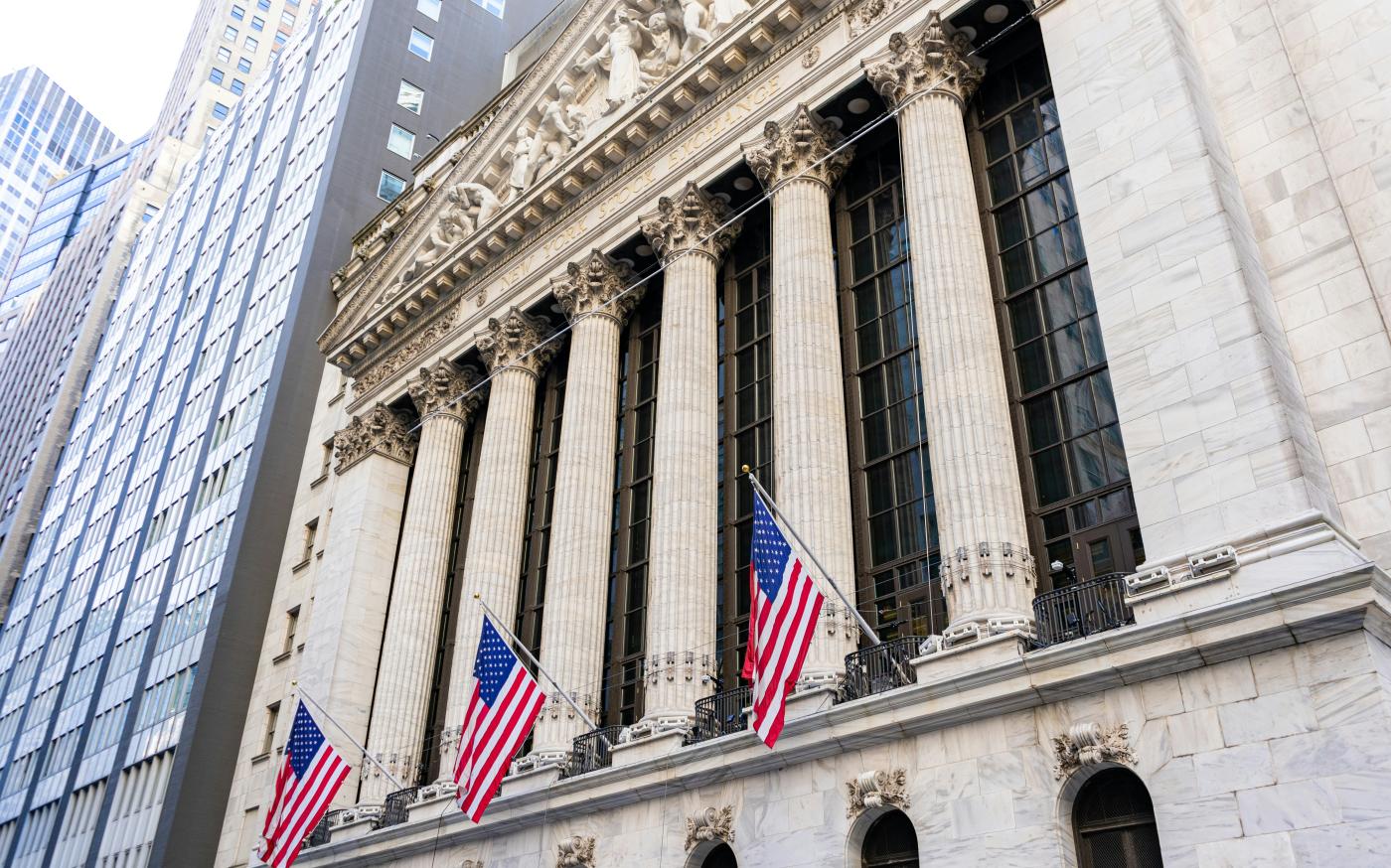 New york stock exchange building with american flags by Maxim Klimashin courtesy of Unsplash.