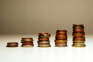 Stacks of coins increasing in height from left to right. by Kamil courtesy of Unsplash.