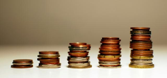 Stacks of coins increasing in height from left to right. by Kamil courtesy of Unsplash.